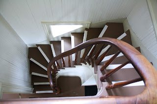 Staircase Looking down into a spiral staircase that is rectangular to match the narrow rectangular walls that border it