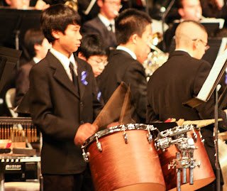 Drummer boy playing tom tom drums in orchestra