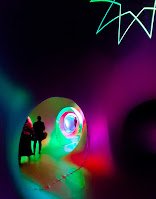 Interior of inflatable art sculpture with people walking through multi-colored tunnels