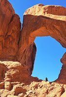 Young man sitting in thought at Double Arch in Arches National Park in Utah