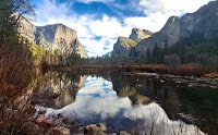 Reflection pool displaying El Capitan and Cathedral Rocks against a blue clouded sky in Yosemite Valley